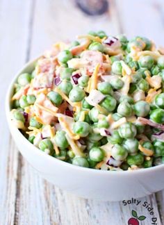 a white bowl filled with peas and cheese