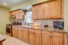 a kitchen with wooden cabinets and tile backsplash