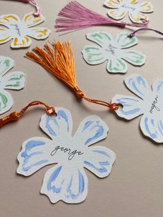 flowers with tassels and name tags on them sitting on top of a table