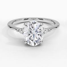 a white gold engagement ring with an oval cut diamond in the center and side stones