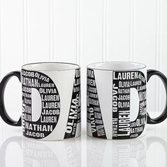 two black and white coffee mugs with different types of words on them, sitting side by side