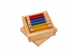 a wooden toy with four different colored blocks in it's holder on a white background