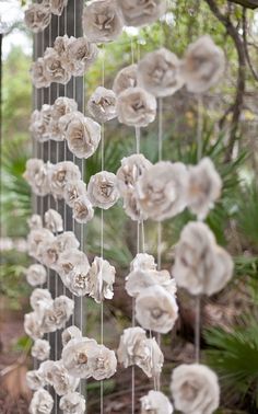 some white flowers hanging from the side of a tree