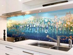 a kitchen with a painting on the wall next to a sink and stove top oven