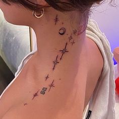 a woman's neck with stars and moon tattoos on her left side ribcage