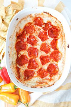 a pepperoni pizza in a white dish with tortilla chips on the side