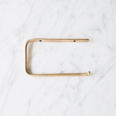 a brass handle on a white marble countertop, with the end cut out to look like a rectangle