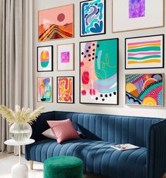 a living room filled with lots of art on the wall above a blue velvet couch