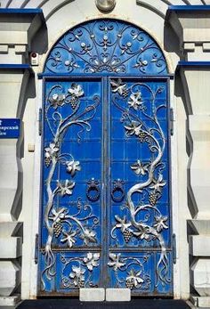 an ornate blue door with vines and flowers on it