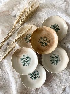 four plates and two stalks of wheat on a lace tablecloth