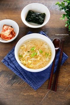 there is a bowl of noodles and chopsticks on the table