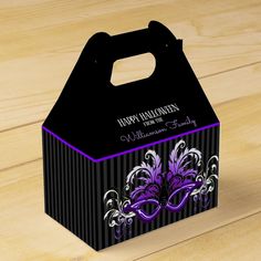 a black and purple halloween treat box on a wooden table