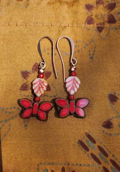 Trees are leafing out and the butterflies return. These boho earrings feature beautiful bright red Czech glass butterfly dangles.  A celebration of Nature and these flying wonders!   I've kept the earrings simple and added small white Picasso-accented leaf beads with highlights that compliment the butterflies. Copper and red Czech glass accent beads.  Rich colors! These petite flying beauties are 1 3/4 inches in length including the copper ear wire hooks.   Lightweight. Handmade. One of a kind.  Unique design. May the joy of butterflies fly into your life:) Bohemian Butterfly Earrings For Pierced Ears, Unique Red Flower Earrings, Bohemian Adjustable Butterfly Earrings, Bohemian Butterfly Jewelry With Pierced Design, Red Bohemian Dangle Flower Earrings, Handmade Pink Butterfly Earrings, Red Bohemian Drop Flower Earrings, Red Butterfly-shaped Jewelry Gift, Festive Red Flower Drop Earrings