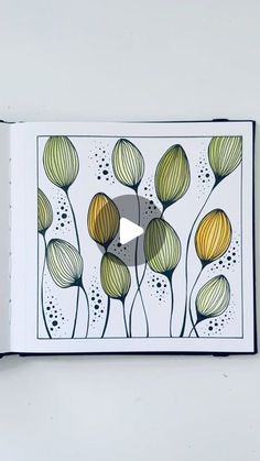 an open book with flowers drawn on the pages and a video playing in front of it