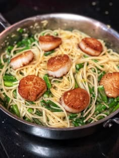 some scallops and noodles in a pan on the stove