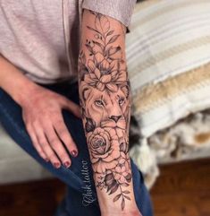 a woman's arm with flowers and a lion tattoo on her left forearm,