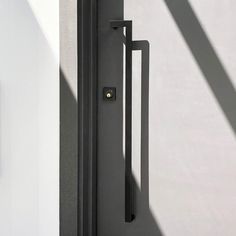 a black door handle on a white wall