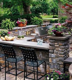 an outdoor kitchen with bar seating and grill