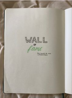 an open notebook with the words wall or fame written in green and black on it