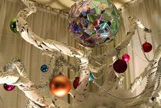 a white christmas tree with ornaments hanging from it's branches