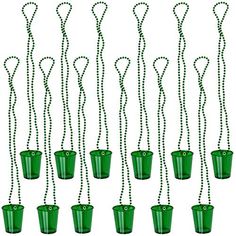 green plastic buckets filled with beads and hanging from strings on a white background photo