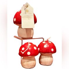 three red mushrooms with white dots on them and a price tag hanging from the top