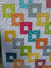 a quilt made with squares and letters on the front, along with an applique