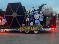 a group of people riding on the back of a truck with star wars characters painted on it