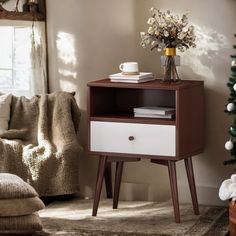 a brown and white end table next to a christmas tree