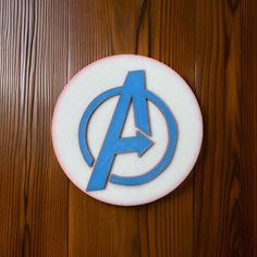 the avengers logo is on top of a wooden wall with wood grained flooring