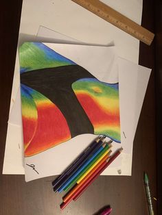 some colored pencils are next to an art project