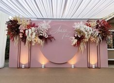 a pink backdrop with flowers and candles on the side for an elegant wedding ceremony or reception