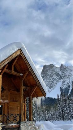 a small wooden cabin with snow on the roof