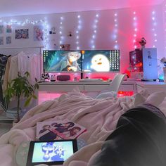 a person laying on a bed in front of two televisions with anime characters on them