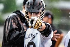 a man wearing a catchers mitt on top of a field in the rain