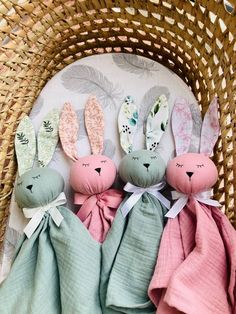 three stuffed bunnies sitting on top of a blanket in a wicker basket next to each other