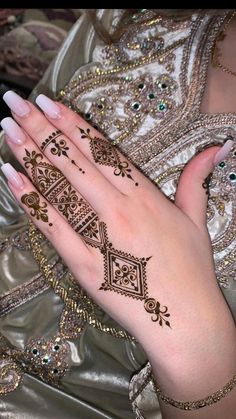 a woman's hand with henna tattoos on it