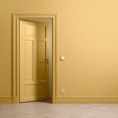 an empty room with yellow walls and a door in the middle is seen from behind