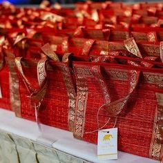 many red bags with gold ribbons on them