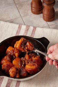 a person is spooning food out of a skillet