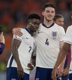 two soccer players hugging each other on the field