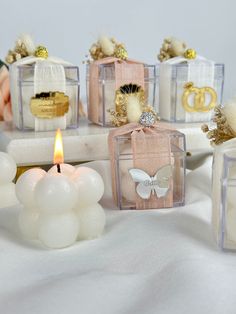 small candles are sitting on a table with white balls and decorations around them in glass cubes