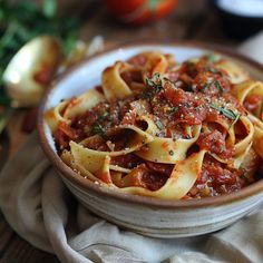 a bowl filled with pasta and sauce on top of a table