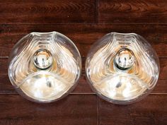 two clear glass vases sitting on top of a wooden table