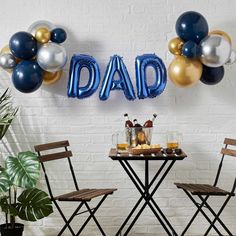 a table with two chairs and balloons that read'dad's day on it