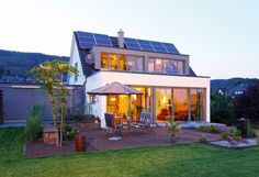 a house that has a patio with chairs and an umbrella