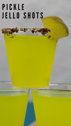 two glasses filled with yellow liquid and topped with a slice of lemon