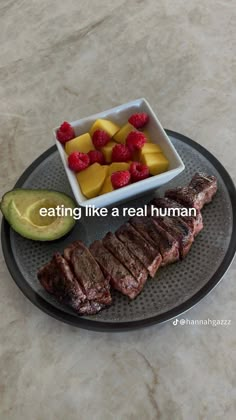 a plate that has some meat and fruit on it