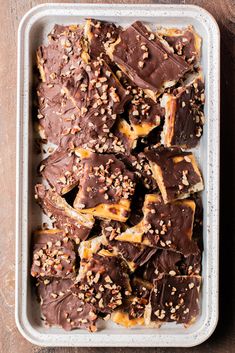 a tray filled with chocolate covered pretzels on top of a wooden table