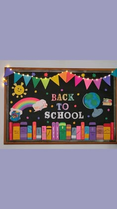 a back to school bulletin board with books and rainbows hanging on the wall above it